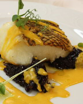 Чилийский сибасс с луковым мармеладом и пряным соусом из батата