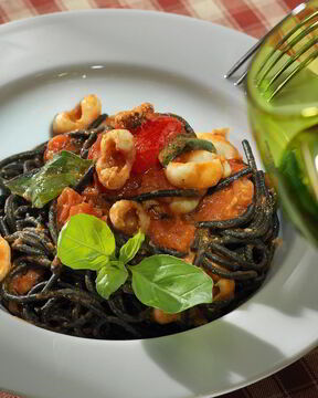 Черные спагетти с соусом из помидоров и каракатиц